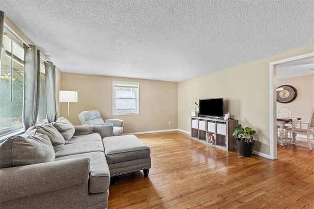 8700 Independence Ave, Kansas City, MO 64125 - living area featuring a textured ceiling, light wood-style floors, and baseboards