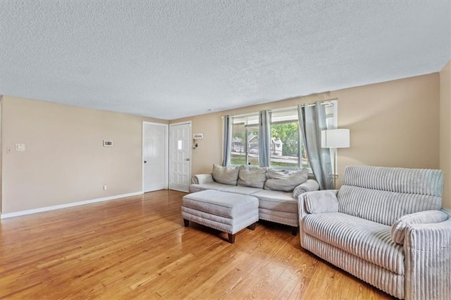 8700 Independence Ave, Kansas City, MO 64125 - living room featuring light wood finished floors, a textured ceiling, and baseboards