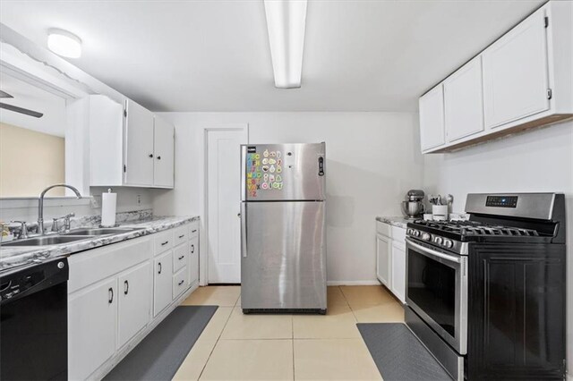 8700 Independence Ave, Kansas City, MO 64125 - kitchen featuring appliances with stainless steel finishes, a sink, white cabinetry, light tile patterned flooring, and light countertops