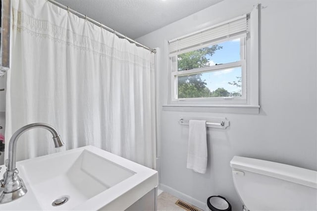 8700 Independence Ave, Kansas City, MO 64125 - bathroom featuring toilet, vanity, a textured ceiling, and a shower with curtain