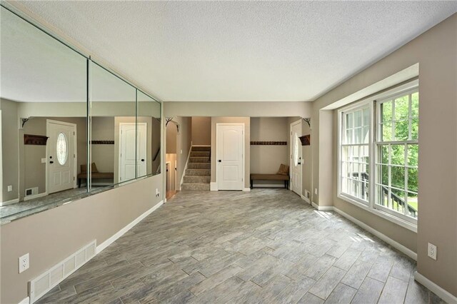 8 Apache Dr, Lake Winnebago, MO 64034 - spare room with a textured ceiling, stairs, wood finished floors, and baseboards