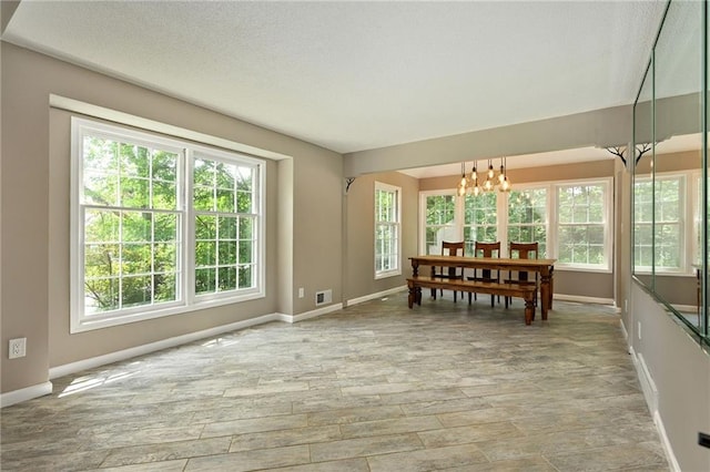 8 Apache Dr, Lake Winnebago, MO 64034 - dining space featuring baseboards, a chandelier, healthy amount of natural light, and a textured ceiling