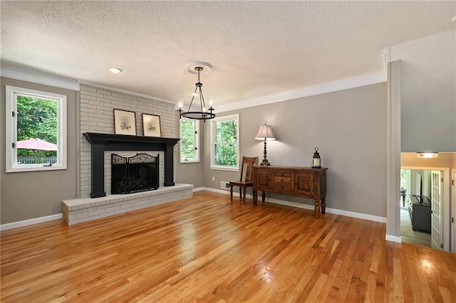 8 Apache Dr, Lake Winnebago, MO 64034 - living area with a textured ceiling, crown molding, light wood-style flooring, baseboards, and a fireplace