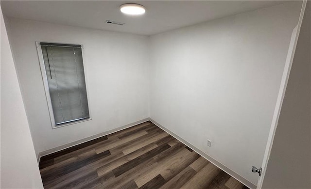 7703 E 107th St, Kansas City, MO 64134 - empty room featuring dark wood-type flooring and baseboards