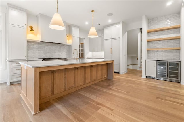 18568 W 180th Ct, Olathe, KS 66062 - kitchen featuring tasteful backsplash, light countertops, light wood-style floors, a large island, and recessed lighting