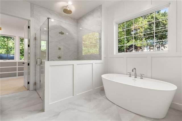 18568 W 180th Ct, Olathe, KS 66062 - full bath featuring a decorative wall, a freestanding tub, a shower stall, marble finish floors, and healthy amount of natural light