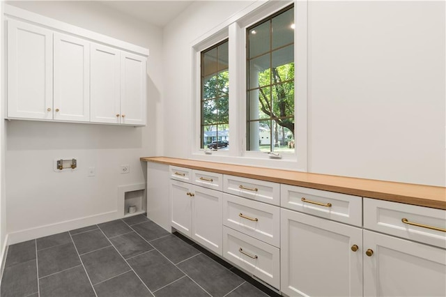 18568 W 180th Ct, Olathe, KS 66062 - laundry area with cabinet space, electric dryer hookup, dark tile patterned flooring, washer hookup, and baseboards