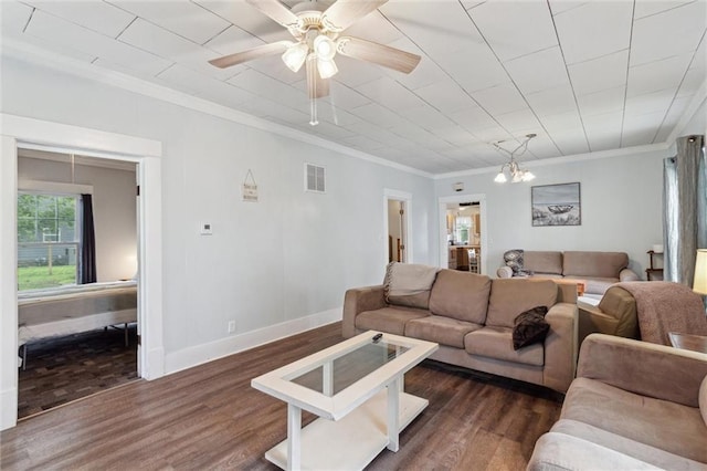 211 S 4th St, Fredonia, KS 66736 - living area with dark wood finished floors, crown molding, baseboards, ceiling fan, and a chandelier