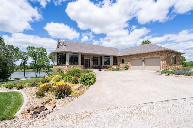 1672 N 1st Rd, Baldwin City, KS 66006 - view of front of home with a garage, concrete driveway, a water view, and stone siding