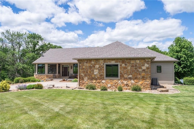 1672 N 1st Rd, Baldwin City, KS 66006 - back of property with stone siding, a yard, cooling unit, and roof with shingles