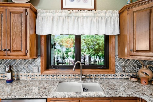 1672 N 1st Rd, Baldwin City, KS 66006 - kitchen featuring a sink, backsplash, brown cabinetry, and light stone counters