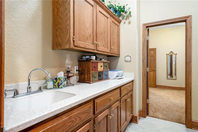 1672 N 1st Rd, Baldwin City, KS 66006 - kitchen with a sink, light countertops, brown cabinetry, light tile patterned floors, and a textured wall