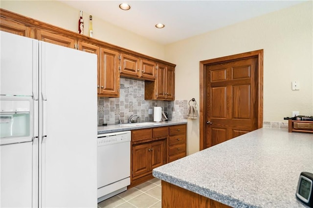 1672 N 1st Rd, Baldwin City, KS 66006 - kitchen featuring white appliances, light countertops, backsplash, a sink, and brown cabinetry