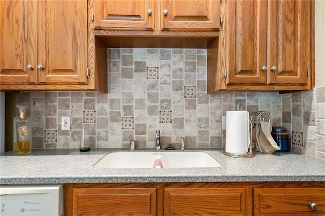 1672 N 1st Rd, Baldwin City, KS 66006 - kitchen featuring a sink, light countertops, brown cabinetry, and backsplash