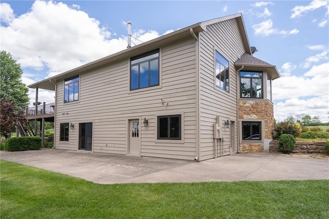 1672 N 1st Rd, Baldwin City, KS 66006 - back of property with stone siding, a patio, and a yard
