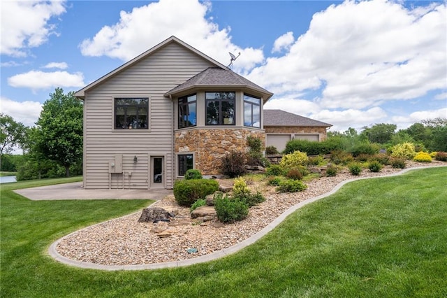 1672 N 1st Rd, Baldwin City, KS 66006 - view of side of home featuring stone siding, a yard, a patio, and roof with shingles