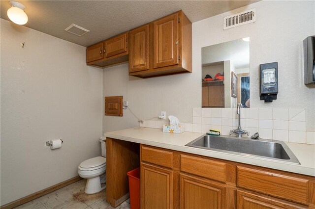 1672 N 1st Rd, Baldwin City, KS 66006 - kitchen with brown cabinets, a sink, light countertops, and tasteful backsplash