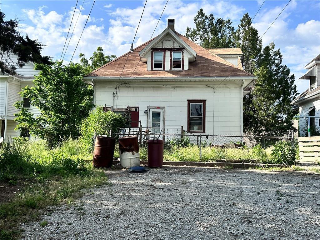 2634 Olive St, Saint Joseph, MO 64507 - rear view of house with a chimney and roof with shingles