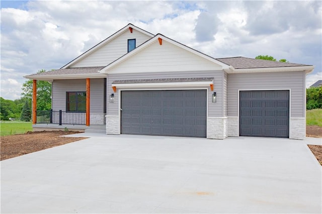 19079 Millstone Ter, Saint Joseph, MO 64505 - view of front facade with a garage, driveway, a porch, and stone siding