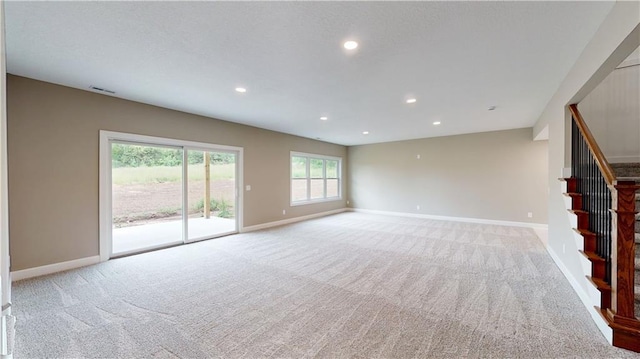 19079 Millstone Ter, Saint Joseph, MO 64505 - unfurnished living room with light colored carpet, stairs, baseboards, and recessed lighting