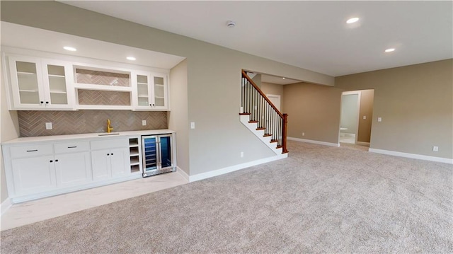 19079 Millstone Ter, Saint Joseph, MO 64505 - indoor wet bar with light colored carpet, stairs, wine cooler, recessed lighting, and tasteful backsplash