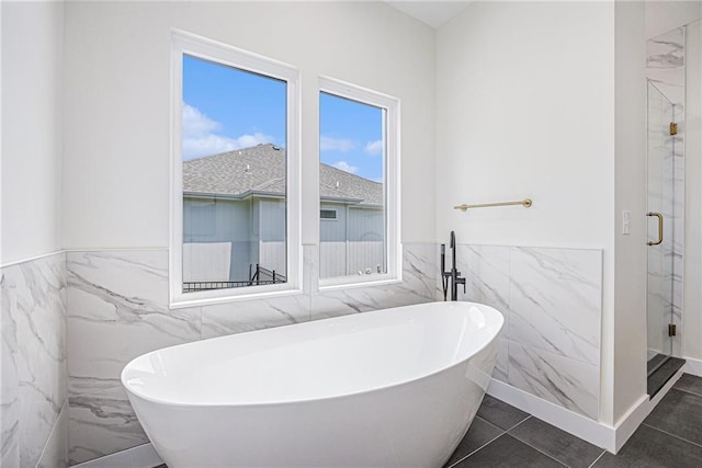 6932 Kenton St, Shawnee, KS 66226 - bathroom with tile walls, a marble finish shower, a soaking tub, and wainscoting