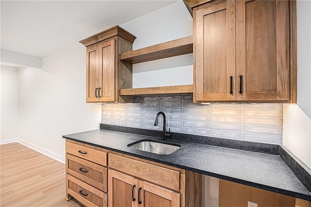 6932 Kenton St, Shawnee, KS 66226 - kitchen featuring open shelves, dark countertops, tasteful backsplash, light wood finished floors, and brown cabinets