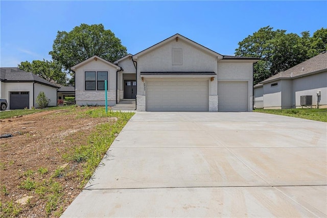 6932 Kenton St, Shawnee, KS 66226 - view of front of home featuring driveway, a garage, and stucco siding