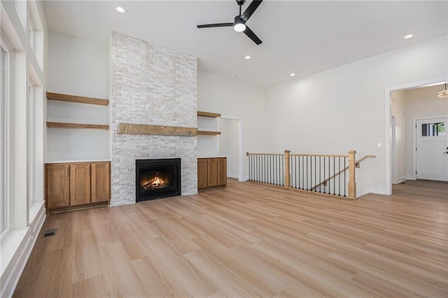 6932 Kenton St, Shawnee, KS 66226 - unfurnished living room with ceiling fan, light wood-style flooring, a stone fireplace, and recessed lighting