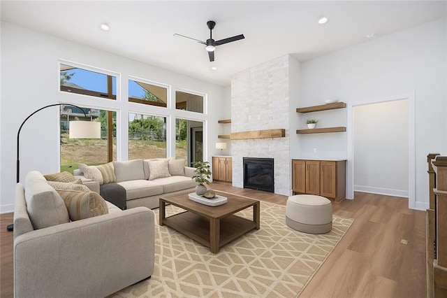 6932 Kenton St, Shawnee, KS 66226 - living area with light wood-type flooring, ceiling fan, a fireplace, recessed lighting, and a towering ceiling