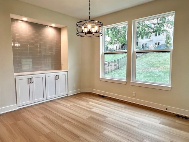 6932 Kenton St, Shawnee, KS 66226 - unfurnished dining area with a chandelier, light wood finished floors, and healthy amount of natural light