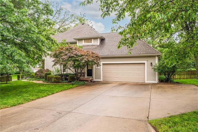 2101 Riviera Dr, Lawrence, KS 66047 - view of front of house with stucco siding, a garage, driveway, and roof with shingles