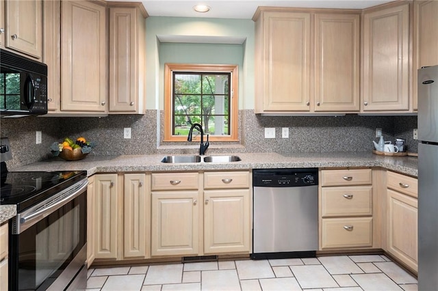 2101 Riviera Dr, Lawrence, KS 66047 - kitchen with stainless steel appliances, a sink, tasteful backsplash, light brown cabinets, and light countertops