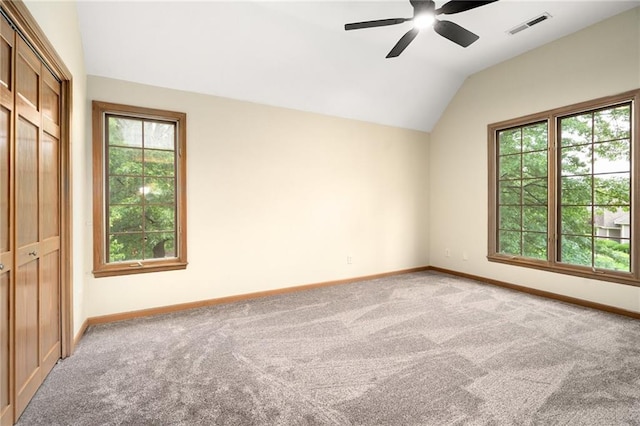 2101 Riviera Dr, Lawrence, KS 66047 - unfurnished bedroom with carpet flooring, vaulted ceiling, multiple windows, and baseboards