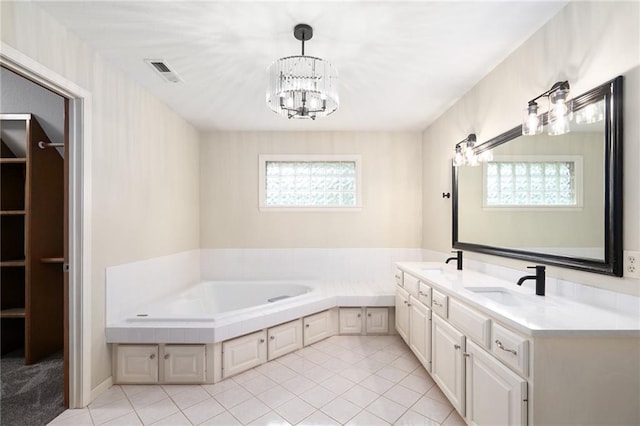 2101 Riviera Dr, Lawrence, KS 66047 - bathroom with a chandelier, a garden tub, double vanity, and tile patterned floors