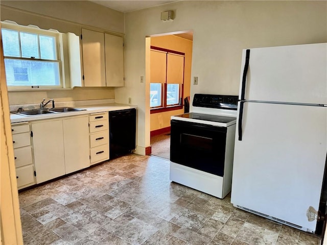 211 Park Ave, Parsons, KS 67357 - kitchen with freestanding refrigerator, electric range oven, black dishwasher, a sink, and light stone finish flooring