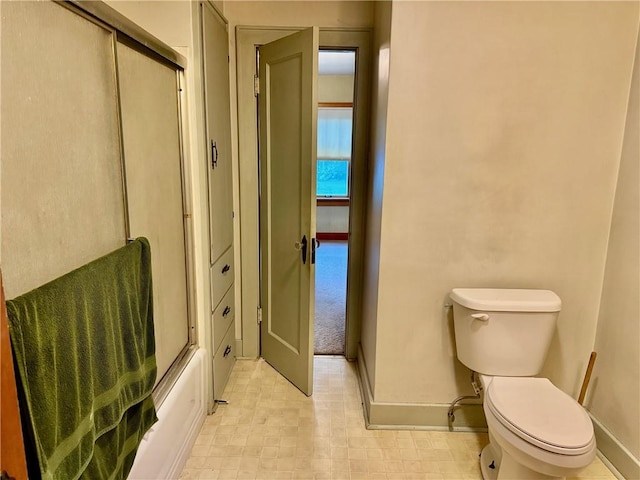 211 Park Ave, Parsons, KS 67357 - bathroom featuring baseboards, toilet, and combined bath / shower with glass door