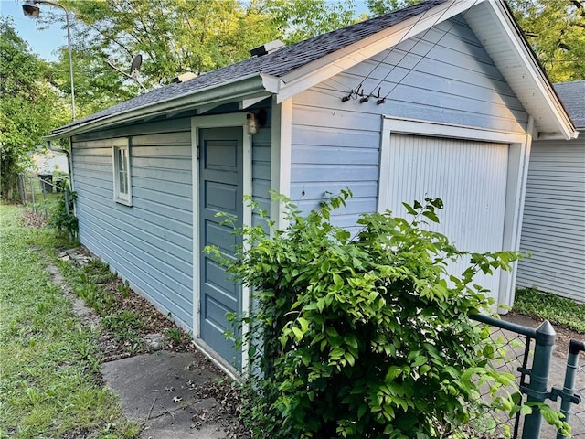 211 Park Ave, Parsons, KS 67357 - view of side of property featuring an outbuilding, a garage, and roof with shingles