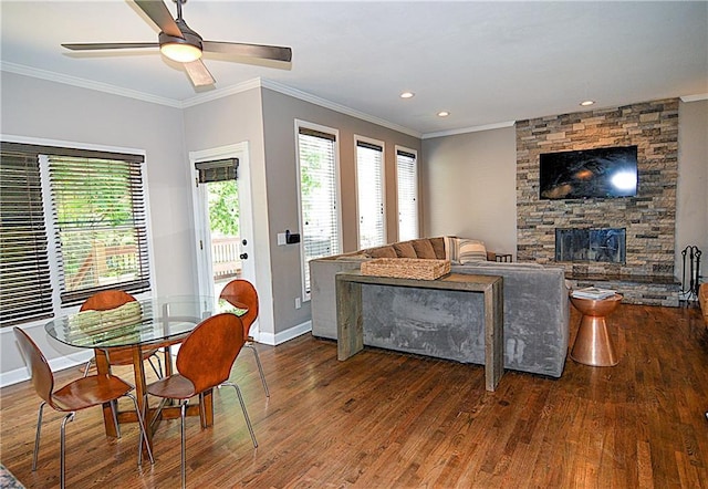 1101 SW Sunflower Dr, Lees Summit, MO 64081 - dining space featuring wood finished floors, crown molding, a ceiling fan, baseboards, and a stone fireplace