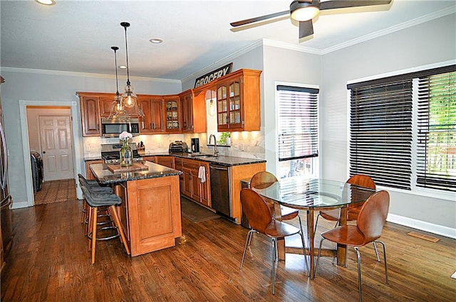 1101 SW Sunflower Dr, Lees Summit, MO 64081 - kitchen featuring stainless steel appliances, a sink, glass insert cabinets, plenty of natural light, and ornamental molding