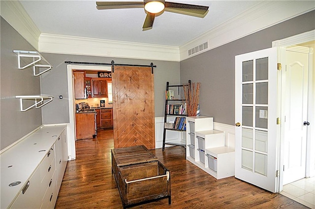 1101 SW Sunflower Dr, Lees Summit, MO 64081 - sitting room with crown molding, a barn door, ceiling fan, dark wood-type flooring, and a wainscoted wall