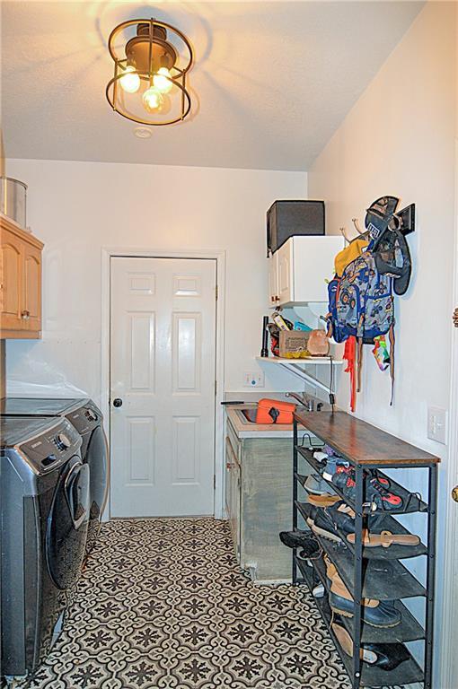 1101 SW Sunflower Dr, Lees Summit, MO 64081 - laundry area with cabinet space and washing machine and dryer