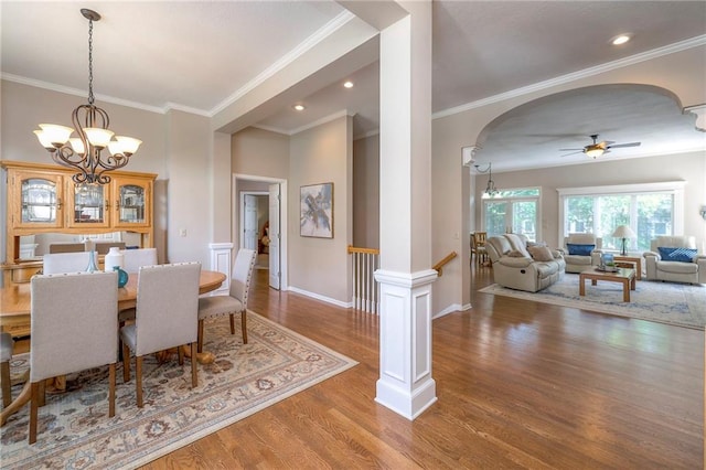 7904 W 153rd Ter, Overland Park, KS 66223 - dining space with arched walkways, crown molding, wood finished floors, a ceiling fan, and a chandelier