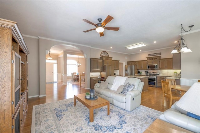 7904 W 153rd Ter, Overland Park, KS 66223 - living room with arched walkways, a ceiling fan, light wood finished floors, recessed lighting, and crown molding