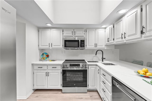 44 G St, Lake Lotawana, MO 64086 - kitchen with stainless steel appliances, white cabinets, and recessed lighting