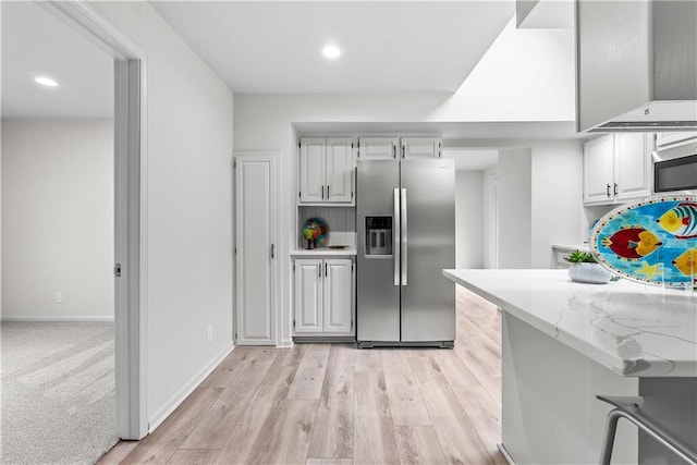44 G St, Lake Lotawana, MO 64086 - kitchen with stainless steel fridge with ice dispenser, light wood finished floors, recessed lighting, light stone countertops, and baseboards