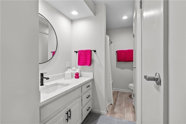 44 G St, Lake Lotawana, MO 64086 - full bathroom with vanity, toilet, baseboards, wood finished floors, and recessed lighting