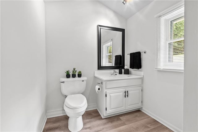 44 G St, Lake Lotawana, MO 64086 - half bathroom featuring toilet, vanity, wood finished floors, baseboards, and vaulted ceiling