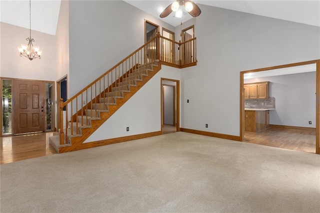 2432 SE 6th St, Lees Summit, MO 64063 - unfurnished living room featuring high vaulted ceiling, light carpet, stairway, and a chandelier