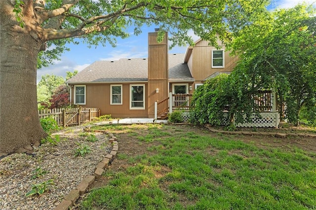 2432 SE 6th St, Lees Summit, MO 64063 - back of property featuring a chimney, a wooden deck, and a shingled roof